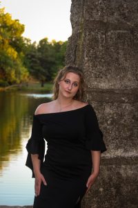 Girl leaning on stone pillar